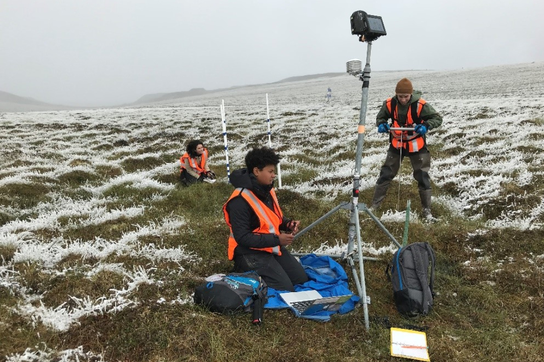 Students in a frosty tundra field using GPS tools